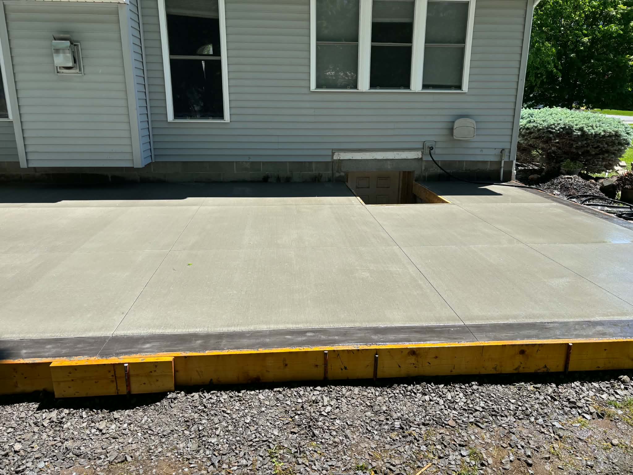 Completed broom-finish concrete patio with smooth picture-frame border in Webster NY
